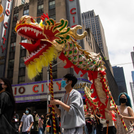Dragon dancer in front of Radio City Music Hall in  AAPI Cultural and Heritage Parade.